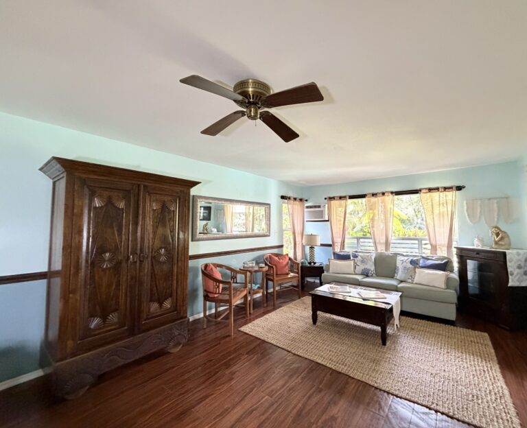 Spacious vacation rental suite with comfortable beds, tropical decor and ceiling fan at Kalani Hawaii on Oahu's North Shore